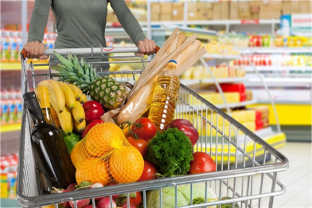 Femme avec panier shopping en supermarché