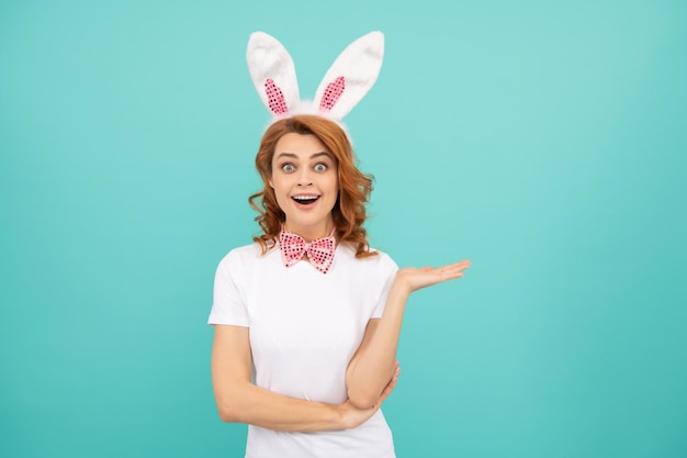 Femme de Pâques étonnée avec des oreilles de lapin sur fond bleu