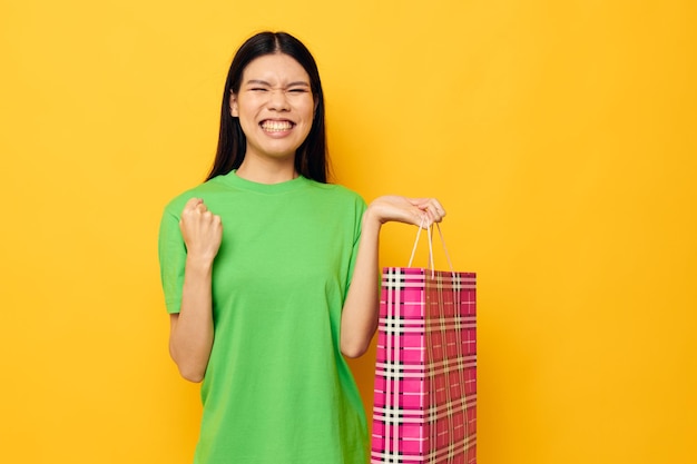 Femme avec paquet de shopping de divertissement d'apparence asiatique fond isolé inchangé