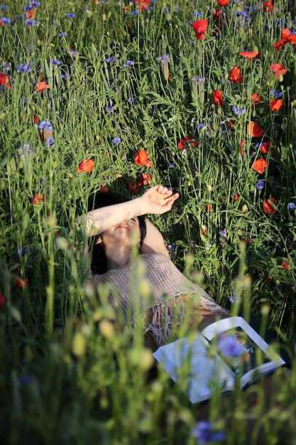 Photo femme par les fleurs dans le champ