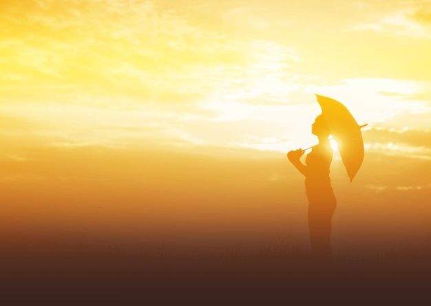 Femme parapluie et silhouette coucher de soleil