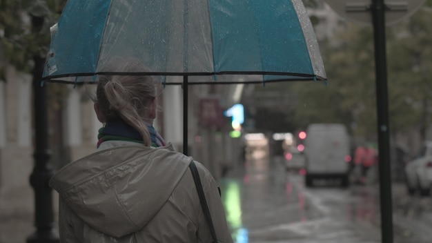 Femme avec parapluie en soirée d'automne