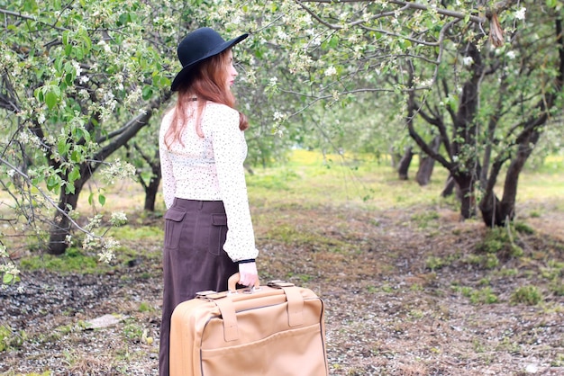 Femme en parc de valise en plein air robe rétro