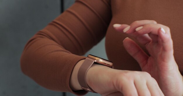 Photo une femme parcourant des montres intelligentes modernes en gros plan une montre intelligente sur le poignet féminin