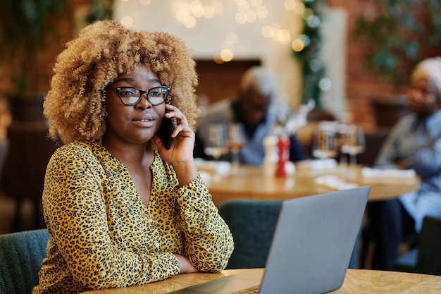 Femme parlant au téléphone au café