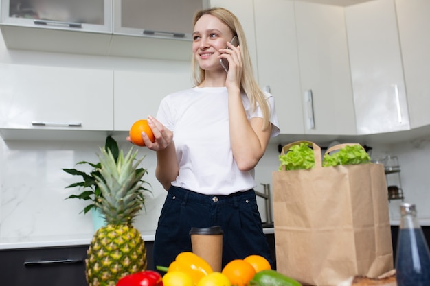 Femme parlant au téléphone dans la cuisine