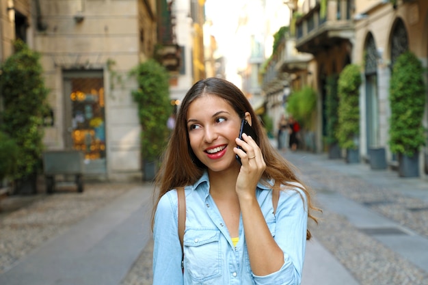 Femme parlant au téléphone mobile à la rue de la ville de Milan en Italie