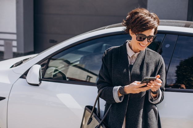 Femme parlant au téléphone par sa voiture