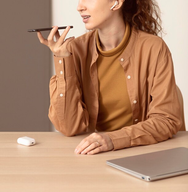 Femme parlant sur le haut-parleur du téléphone mobile