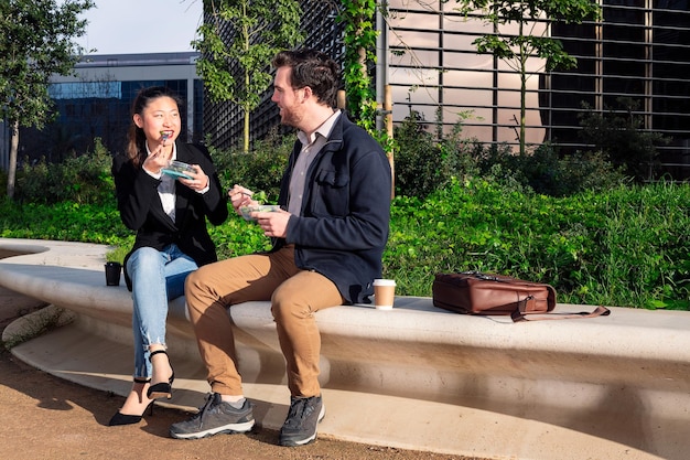 Femme parlant et mangeant une salade avec son partenaire