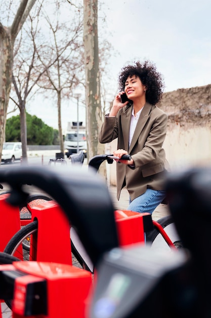 Femme parlant par téléphone assis sur une station vélo