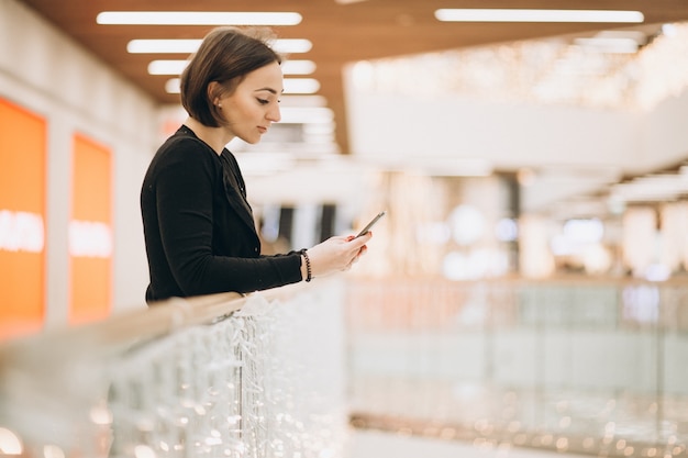 Femme parlant sur un téléphone dans un centre commercial