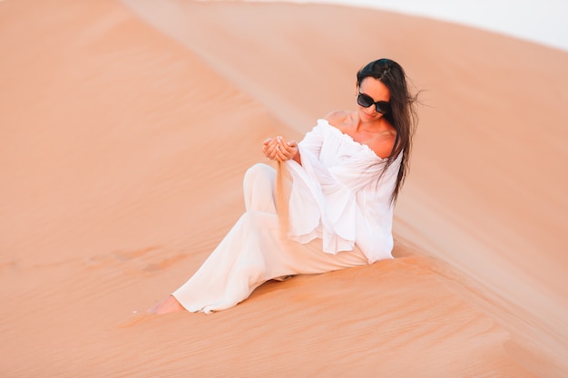 Femme parmi les dunes dans le désert aux Emirats Arabes Unis