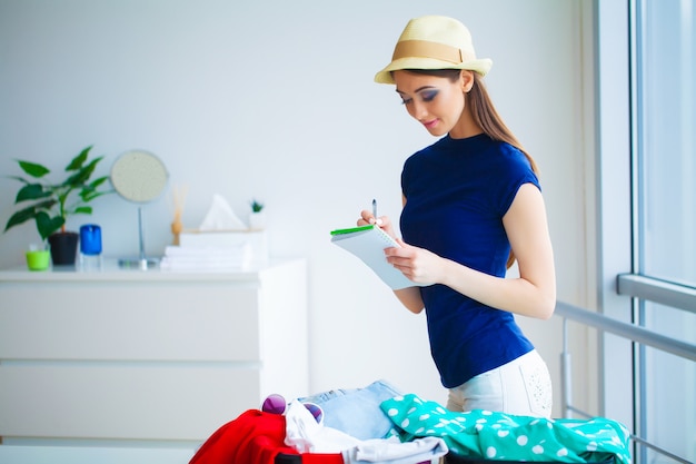 Femme part en vacances et met des vêtements dans une valise