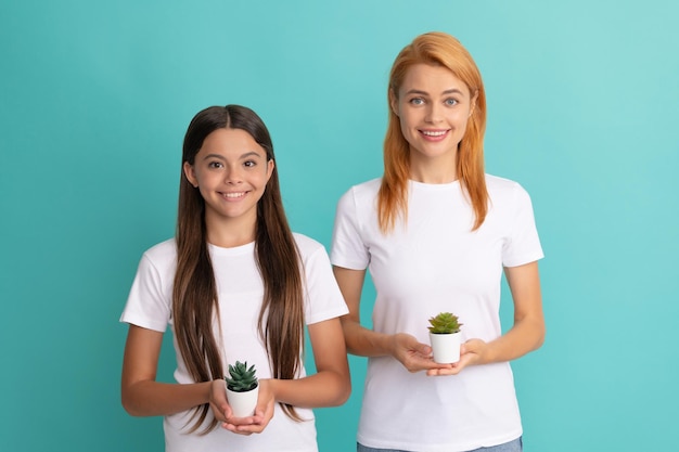 Une femme partage une vraie joie d'être maman Une femme heureuse et une fille tiennent des plantes en pot Mère et fille enfant