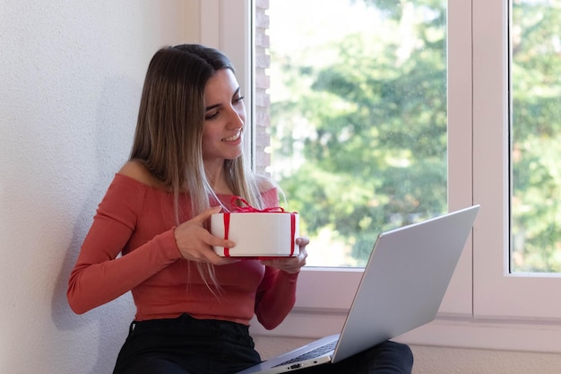 Femme passant un appel vidéo et surprenant ses proches avec un cadeau