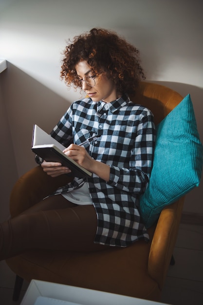 Femme passant son temps libre à planifier son agenda pas de connexion internet cheveux bouclés