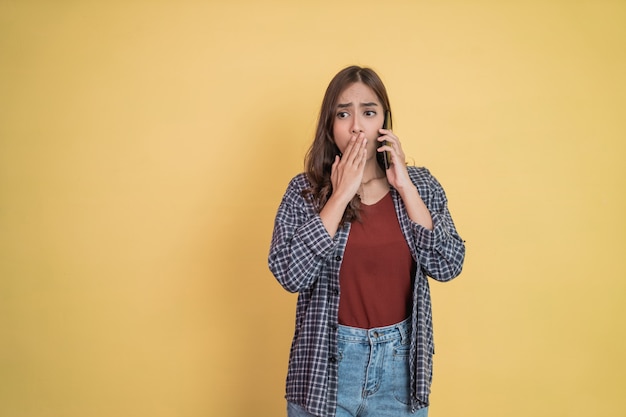 Une femme passe un appel avec un téléphone portable avec un geste surpris avec copyspace