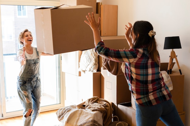 Une femme passe une boîte en carton à une autre femme pour la mettre en tas Espace de copie Concept en mouvement