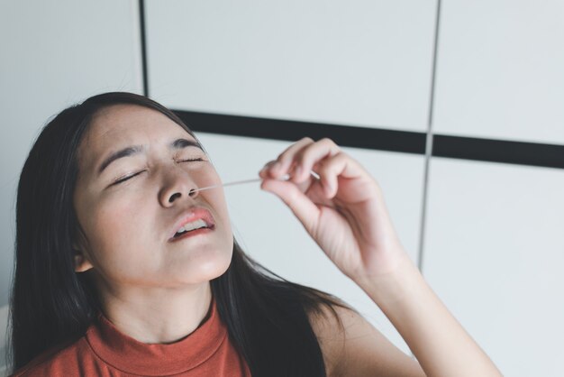 Femme patiente faisant un kit de test rapide d'antigène d'auto-test par écouvillon nasal pour vérifier un covid-19 à la maison