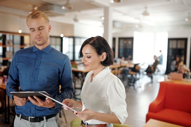 Femme PDG de l'entreprise demandant au chef de service les détails du rapport mensuel qu'il a fait