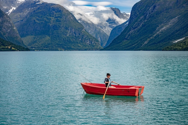 Femme pêchant sur un bateau. Belle Nature Norvège paysage naturel. lac lovatnet vallée de Lodal.