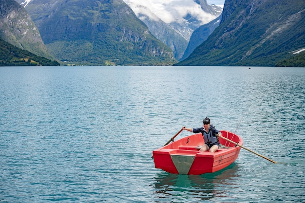 Femme pêchant sur un bateau. Belle Nature Norvège paysage naturel. lac lovatnet vallée de Lodal.