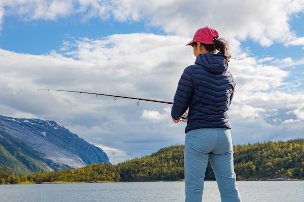 Femme pêchant sur la filature de canne à pêche en Norvège. La pêche en Norvège est un moyen d'adopter le mode de vie local. D'innombrables lacs et rivières et un littoral étendu offrent des opportunités exceptionnelles...