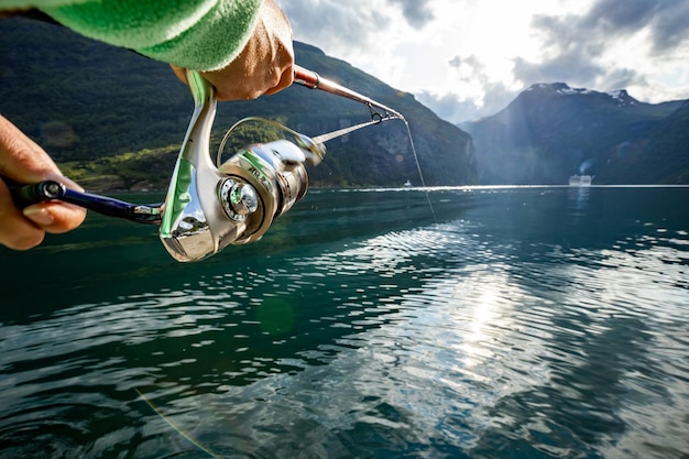 Femme pêchant sur la filature de canne à pêche en Norvège. La pêche en Norvège est un moyen d'adopter le mode de vie local. D'innombrables lacs et rivières et un littoral étendu offrent des opportunités exceptionnelles...