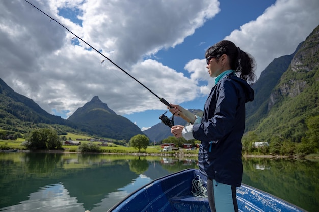 Femme pêchant sur la filature de canne à pêche en Norvège. La pêche en Norvège est un moyen d'embrasser le mode de vie local. D'innombrables lacs et rivières et un littoral étendu signifient des opportunités exceptionnelles...