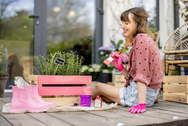 Femme peignant une boîte en bois faisant des travaux ménagers à l'extérieur