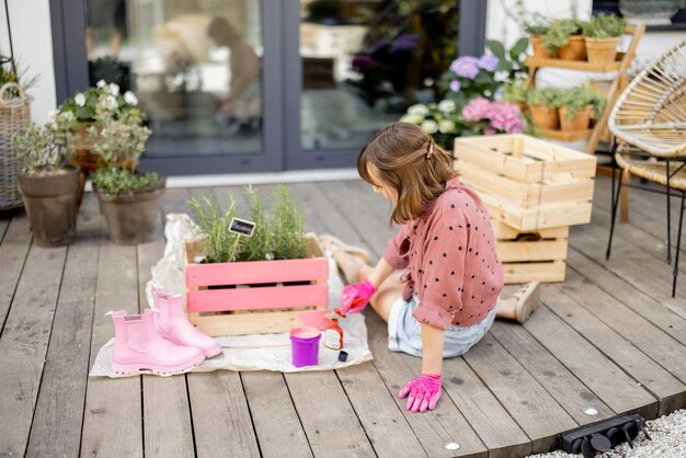 Femme peignant une boîte en bois faisant des travaux ménagers à l'extérieur