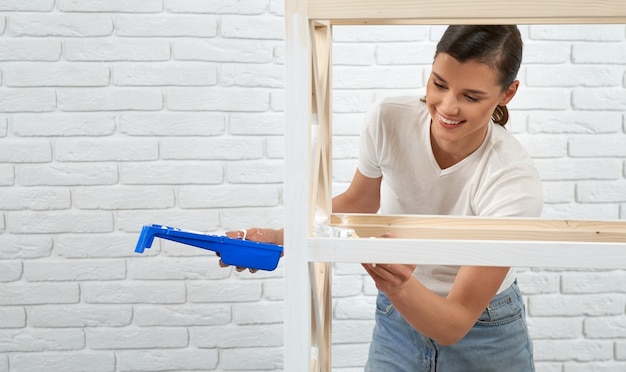 Femme peignant avec un pinceau et un support de rangement de couleur blanche