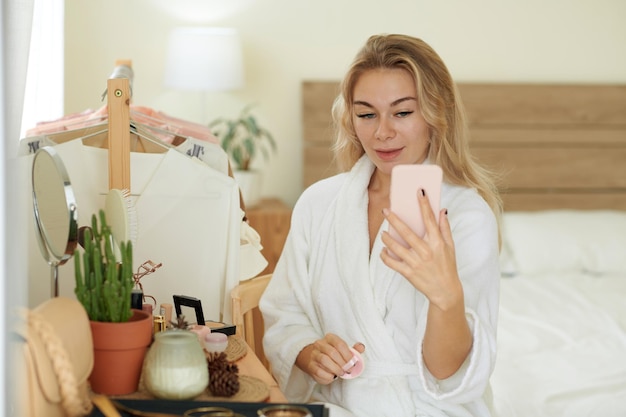 Femme en peignoir prenant Selfie