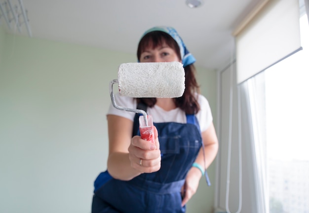 Une femme peintre posant avec un rouleau