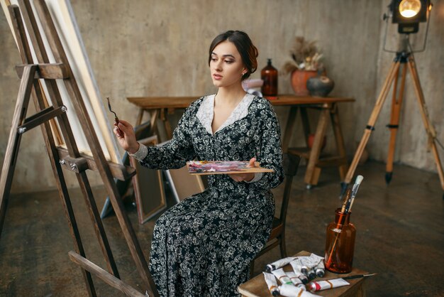 Femme peintre pose en studio d'art