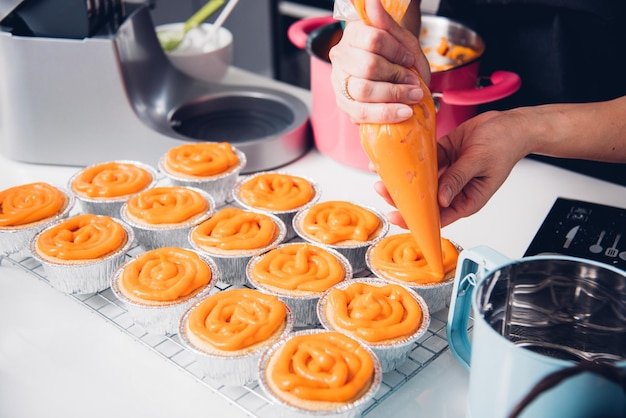 Femme pendant la fabrication de la décoration du gâteau de boulangerie