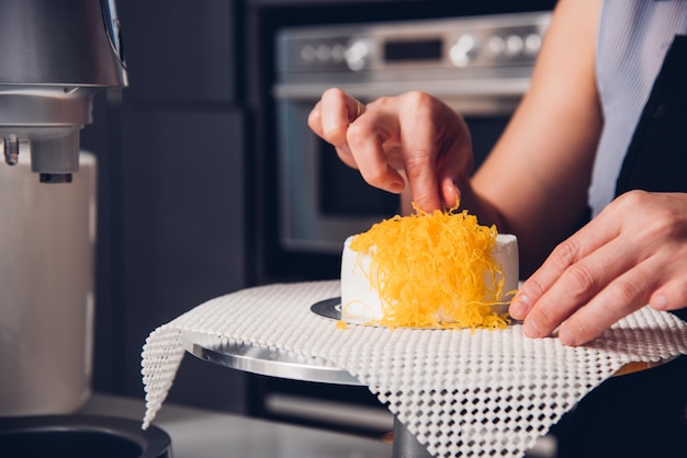 Femme pendant la fabrication du gâteau de décoration