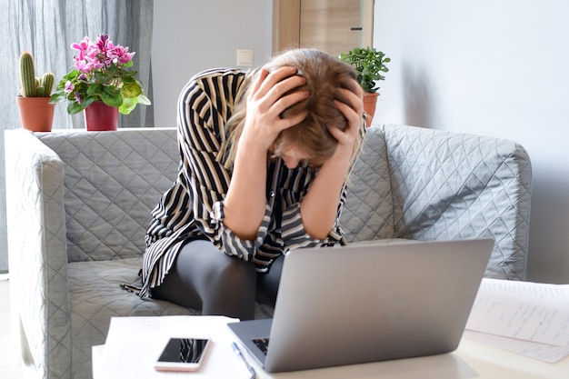 femme pense à travailler avec un ordinateur portable à table. difficultés problèmes au travail