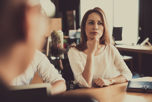 Femme pensive aux cheveux roux assis sur un entretien