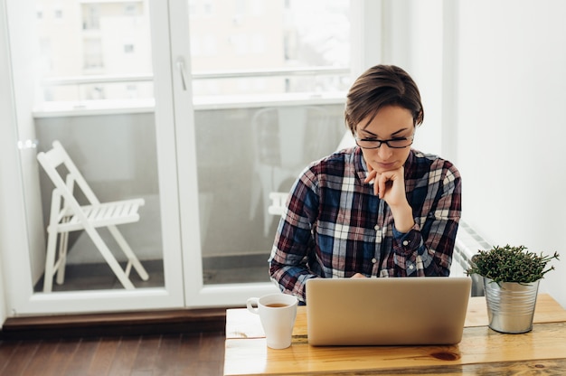 Femme pensive travaillant à la maison