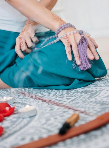 Femme avec des perles de mala lilas sur ses mains henné mehendi