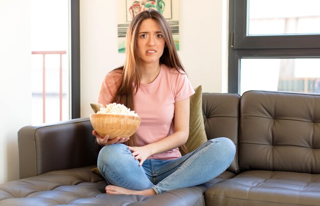 Femme à la perplexe et confuse, mordant la lèvre avec un geste nerveux, ne sachant pas la réponse au problème