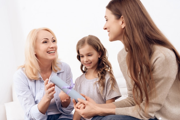 Femme avec une petite fille mignonne donne un certificat de femme mûre.