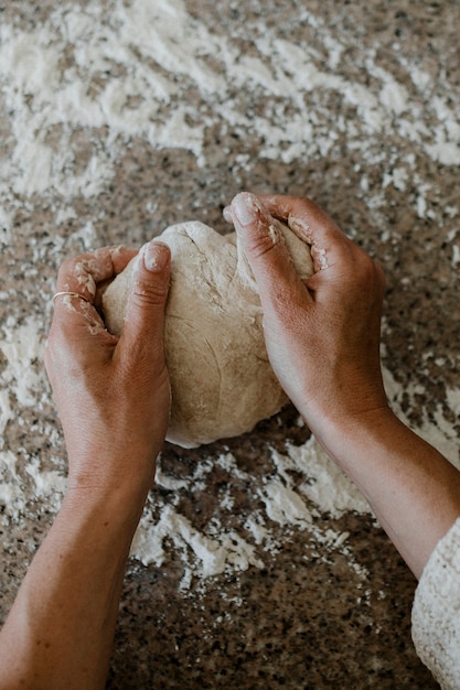 Femme pétrissant le levain dans sa cuisine