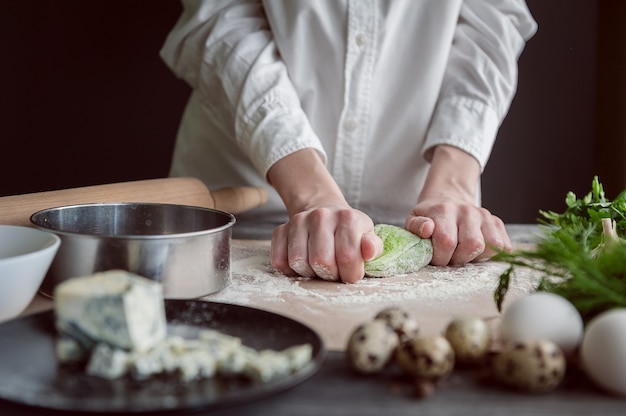 Femme pétrit la pâte pour les raviolis