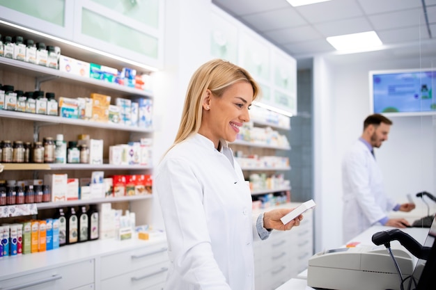 Femme pharmacien caucasien vendant des médicaments en pharmacie.