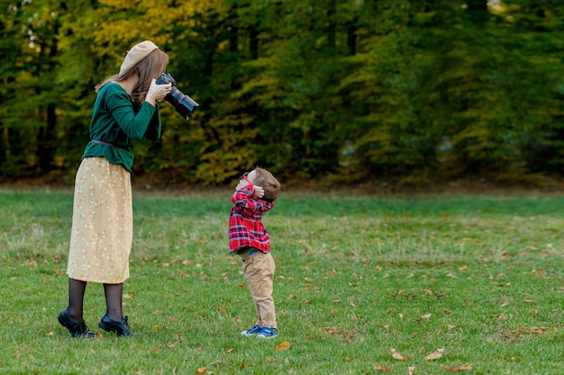 Femme photographe photographiant l'enfant dans le parc