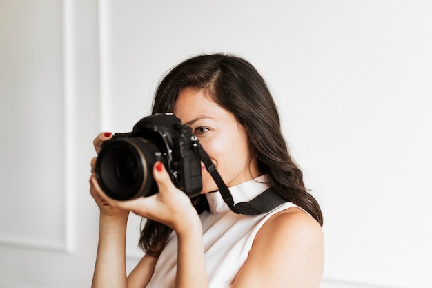 Femme photographe tenant un appareil photo numérique