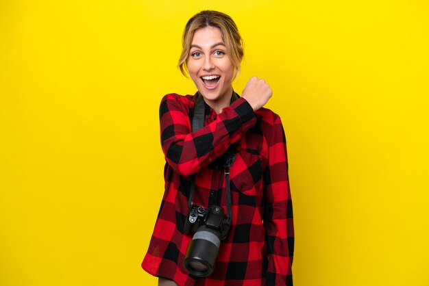 Femme photographe uruguayenne isolée sur fond jaune célébrant une victoire